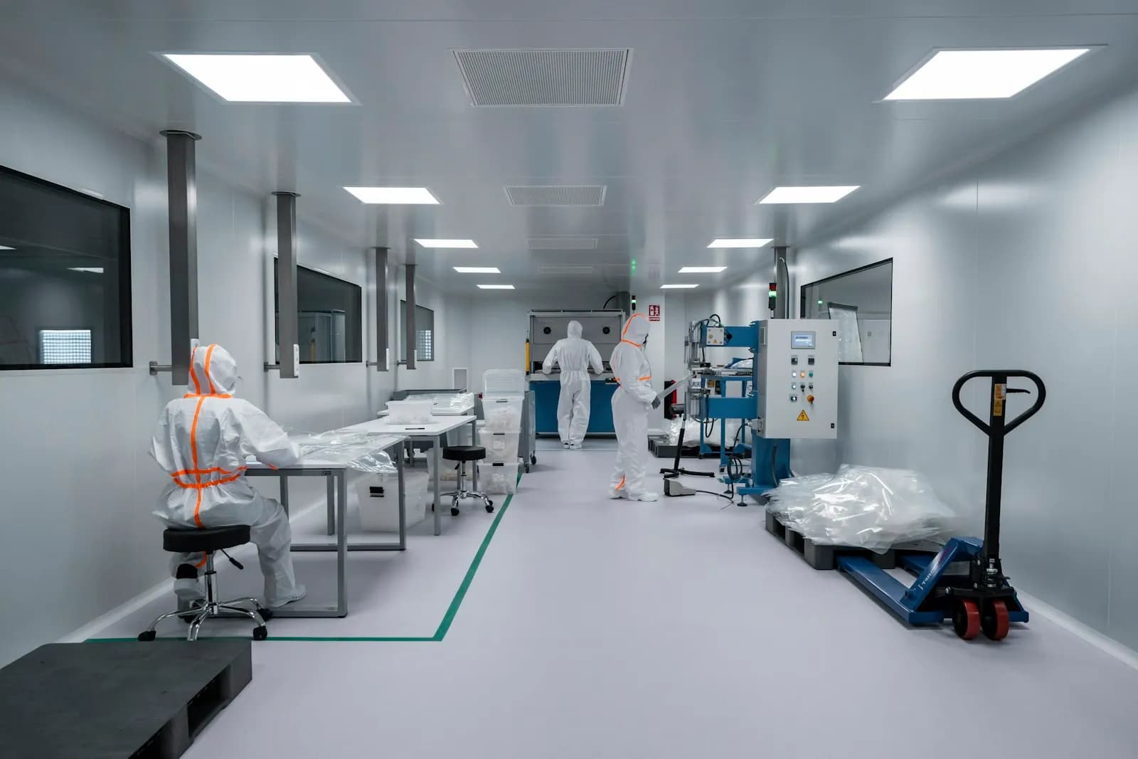 Sala limpa com profissionais em trajes de proteção